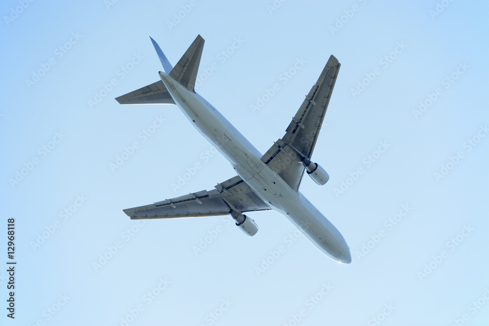 Commercial Airplane Flying Against A Blue Sky Commercial Airplane Flying Against A Blue Sky
