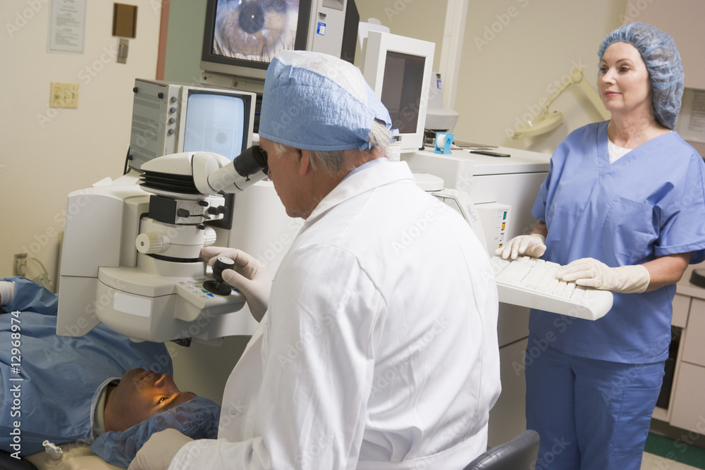 Doctor Checking Patient's Eyes With Nurse Assisting