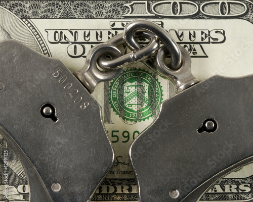 Cropped handcuffs on a one hundred dollar bill