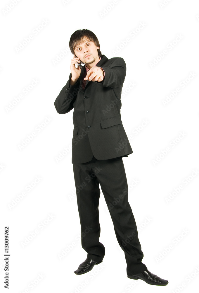 Angry businessman talking by cellular and pointing at you Angry businessman talking by cellular and pointing at you