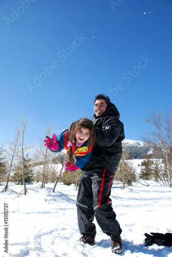 papa qui joue avec sa fille au sport d'hiver.