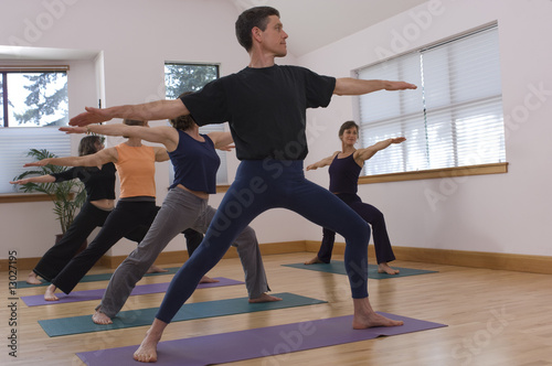 Teacher guides student in yoga class