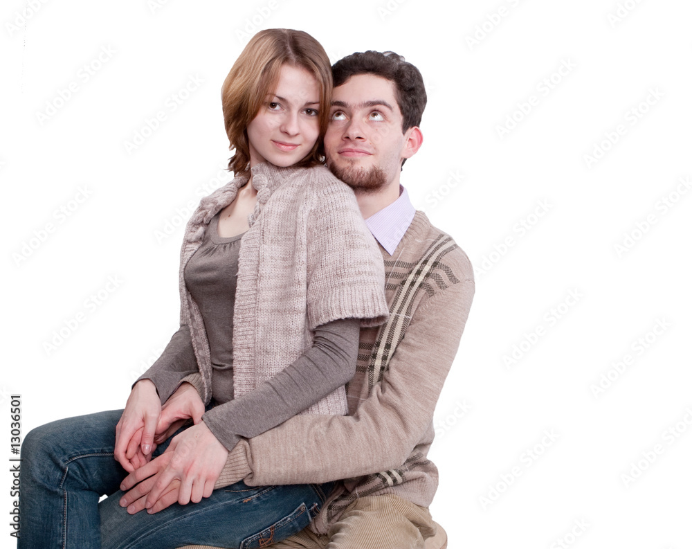 Young couple in tender hug. Woman is holding a gerber Young couple in tender hug. Woman is holding a gerber