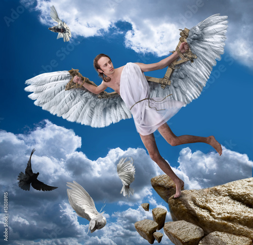 A young man with wings on a background of blue sky. photo