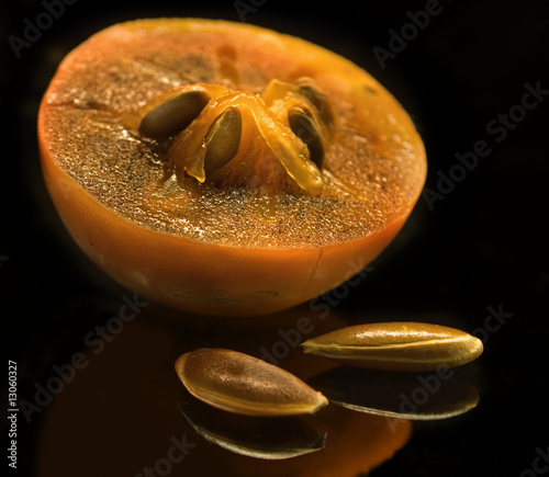 The juicy persimmon cut half-and-half on a black background.