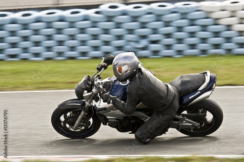 Fotografie Motard sur circuit avec mur de pneus de protection