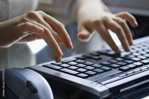 Female hands on the black keyboard.