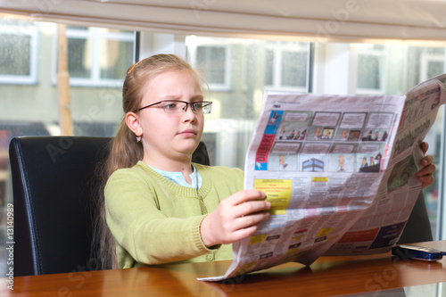 young girl reading newspaper