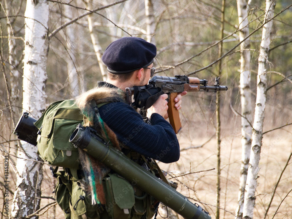 Fototapeta premium Man aiming with rifle in forest