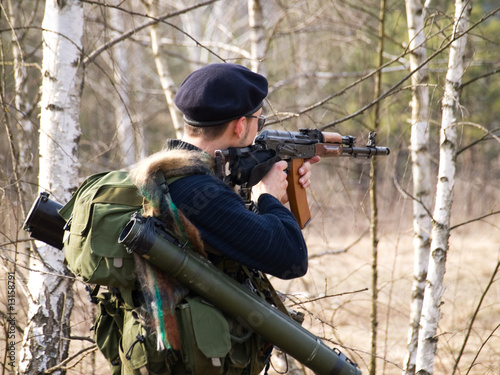 Man aiming with rifle in forest