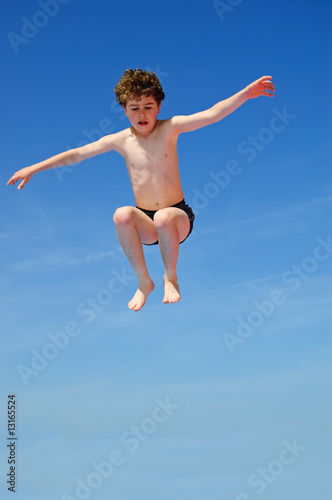 Boy jumping against blue sky