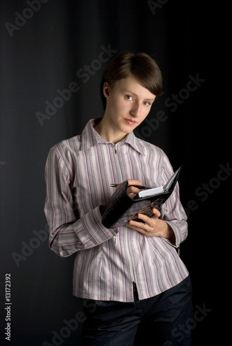 Business woman with a planner making notes on black background photo