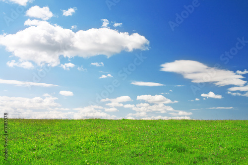 Green hill under blue cloudy sky