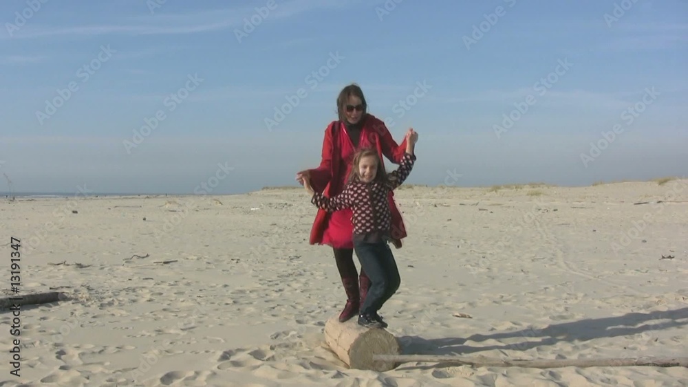 mère et fille dansant sur la plage au ralenti