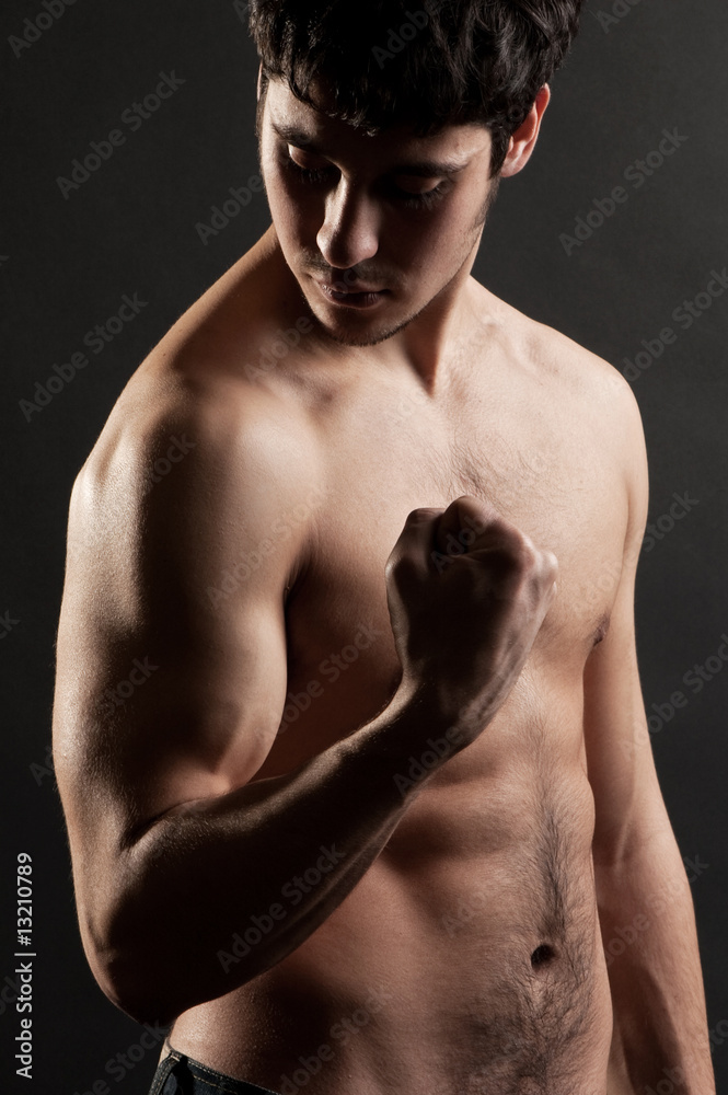 Fototapeta premium sportsman looking at his biceps