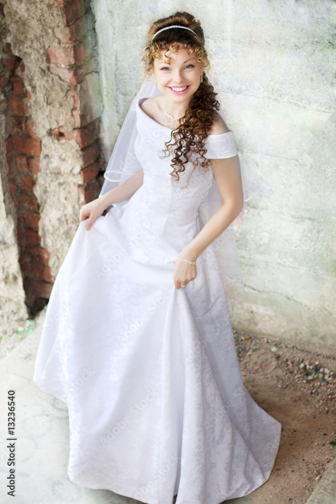 Curly bride against the backdrop of the stone ruins Curly bride against the backdrop of the stone ruins