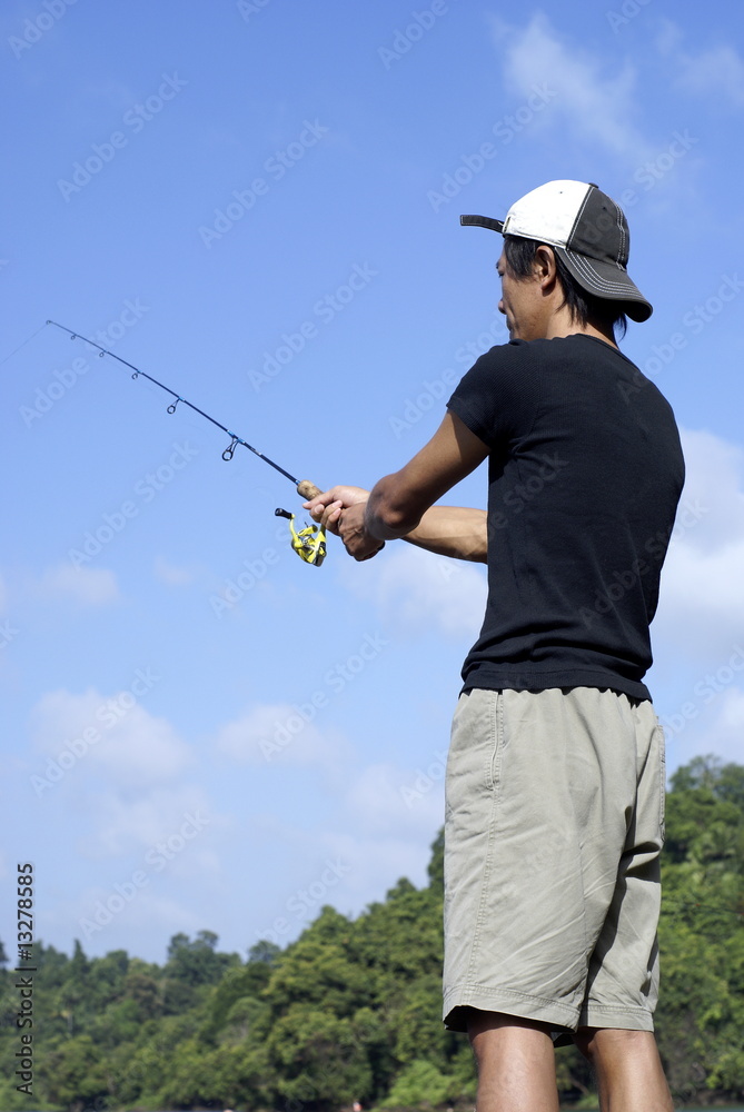Asian man fishing outdoors Asian man fishing outdoors