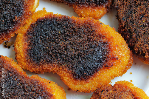 Slightly burnt chicken cutlets on the plate.