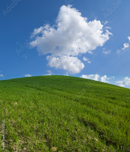 green hill with white clouds