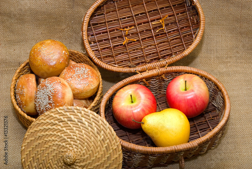 Baskets with rolls and fruits photo