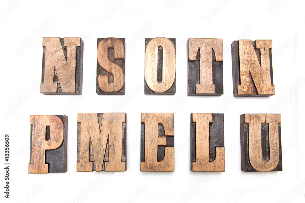 Wooden letterpress printing blocks on a white studio background. Wooden letterpress printing blocks on a white studio background.