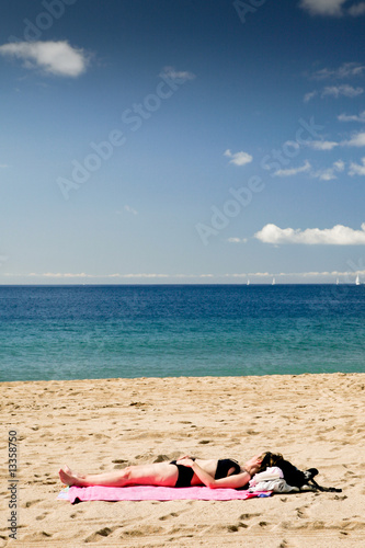 Femme bronzant sur une plage