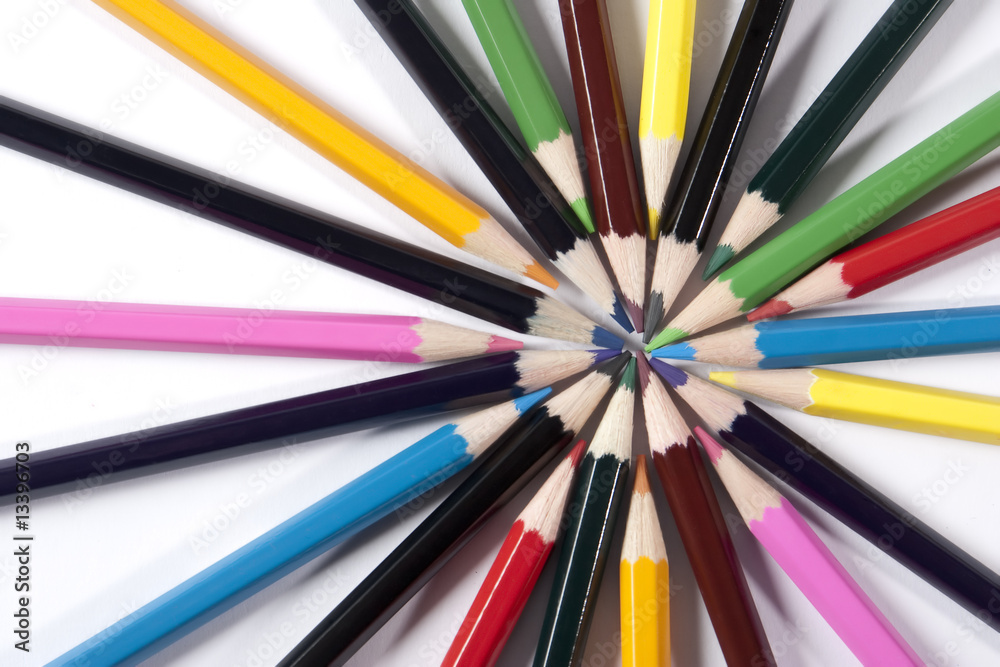 Fototapeta premium Colored pencils organized in a nice way on a while background.