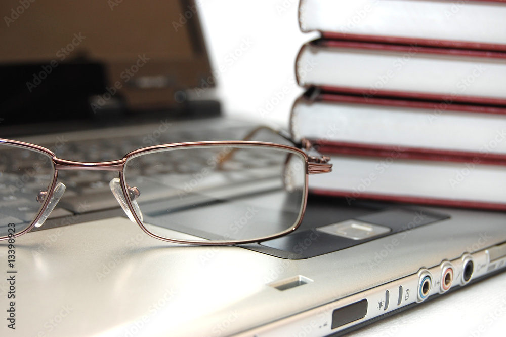 Eyeglasses and books on the laptop Eyeglasses and books on the laptop