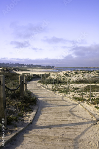 Railing and boardwalk over sand dunes and blue sky on the Califo