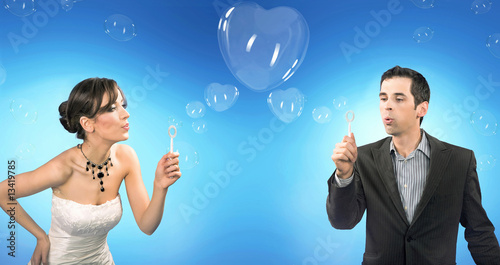 Wedding couple blowing heart shaped romantic soap bubbles © konradbak