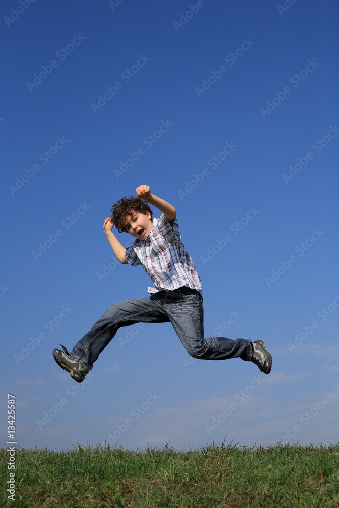 Boy jumping, running against blue sky Boy jumping, running against blue sky