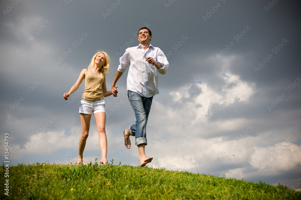 Young couple walking through summer lawn