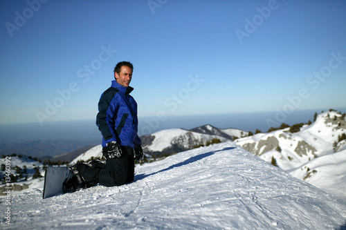 homme avec snowboard à genoux dans la neige