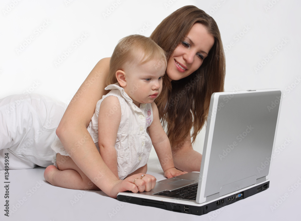 beautiful mother with daughter looking on the laptop