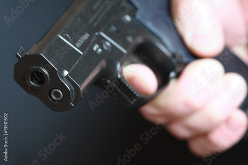 Hand with pistol on dark background