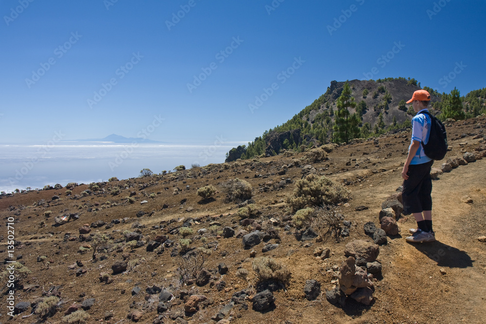 Boy looking at Tenerife from volcanic landscape La Palma