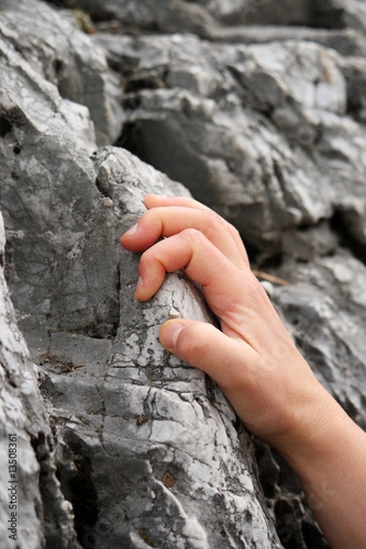 Hand holding tight on a rock