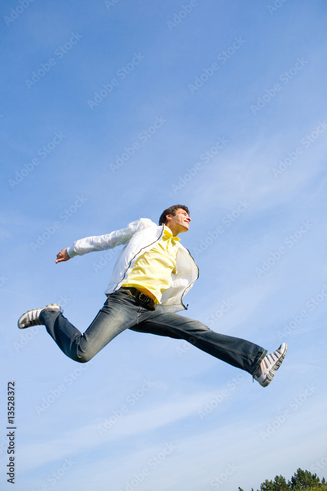 Happy young man - jumping  end flies in blue sky