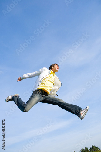 Happy young man - jumping  end flies in blue sky