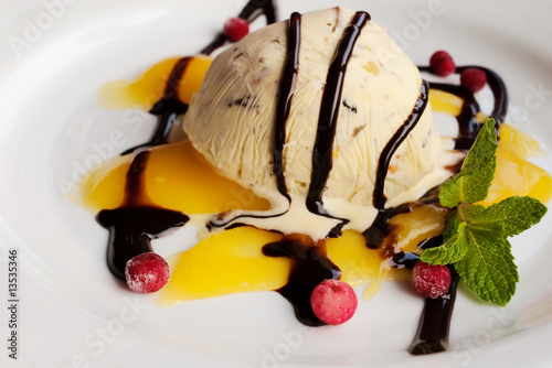ice cream ball topped with chocolate and vanilla sauce