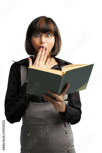 Surprised brunette schoolgirl looking front and hold book