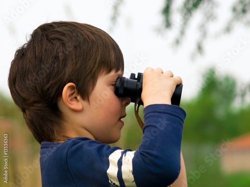 a boy looking through binoculars