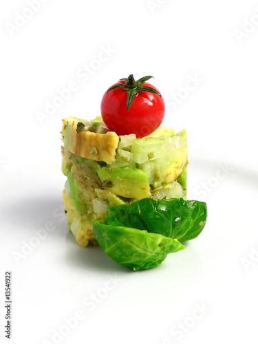 Guacamole tower with cherry tomato on white background
