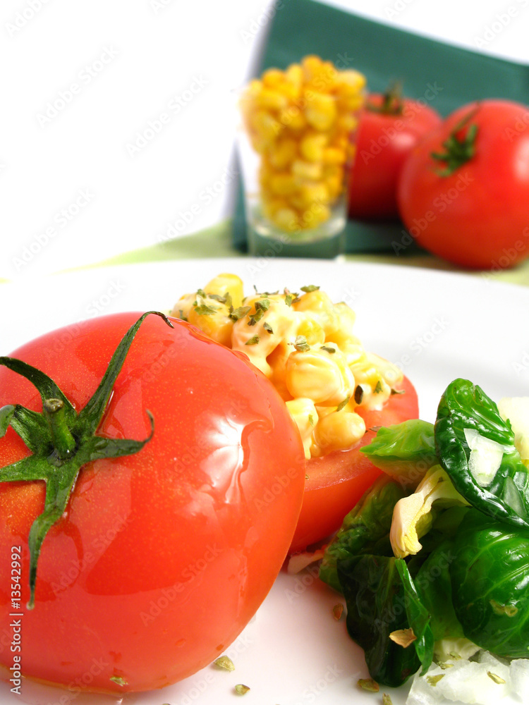 Tomato Stuffed with corn and mayonnaise on white dish Tomato Stuffed with corn and mayonnaise on white dish