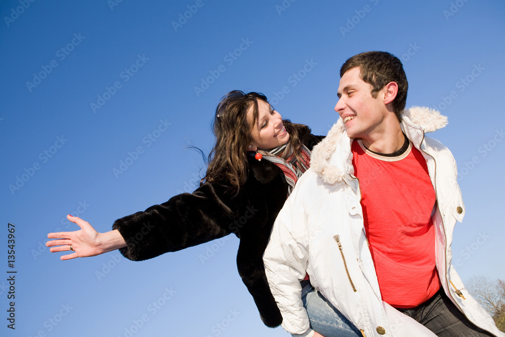 Young love couple smiling under blue sky Young love couple smiling under blue sky