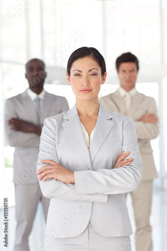 Serious Business woman standing in front of a business team