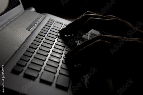 Hacker is up to something in a dark room.