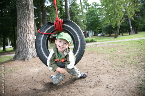Young boy playing in tire swing