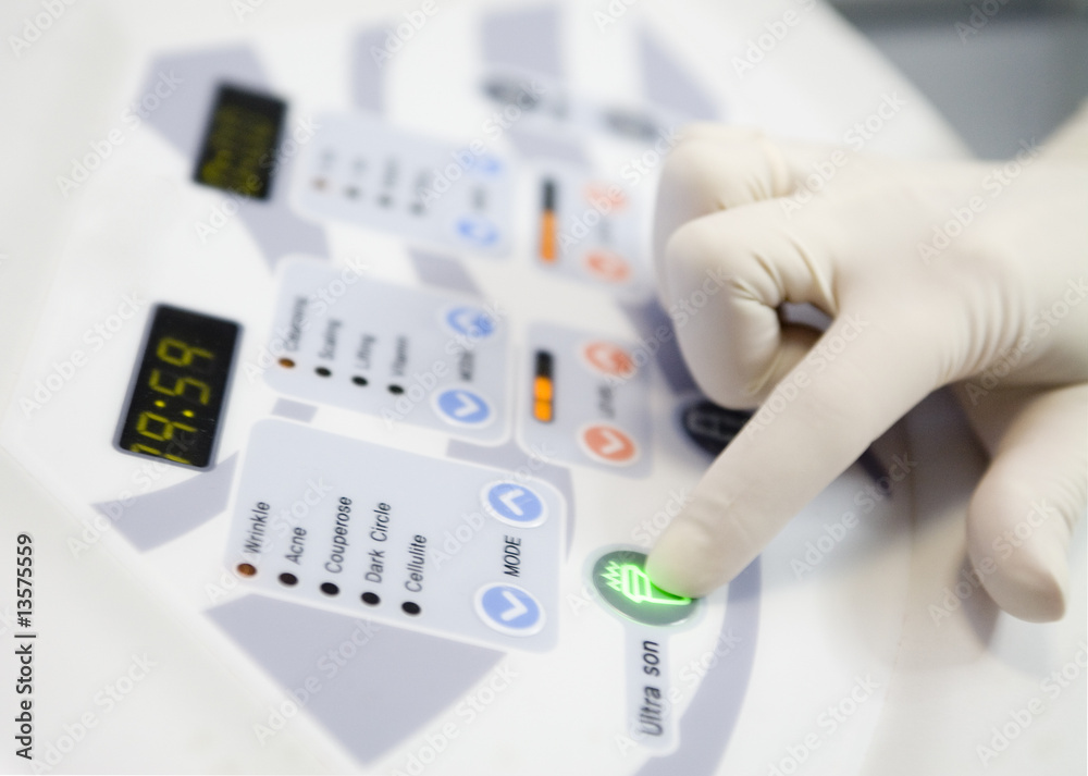 Woman hand is turning on cosmetology unit