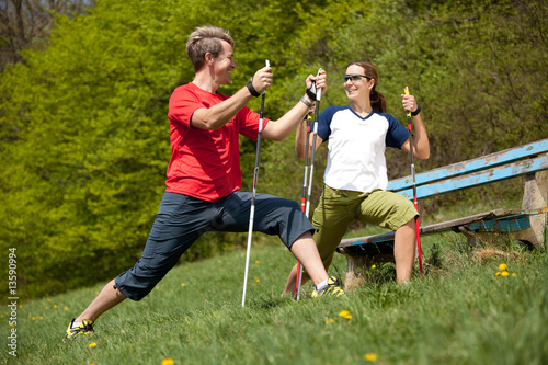 happy couple stretching with nordic walking sticks